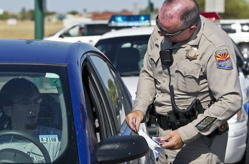 Police officer performing roadside mobile driver’s license verification during a traffic stop