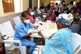 Nurse drawing blood from a patient at a Senegal CMU healthcare clinic